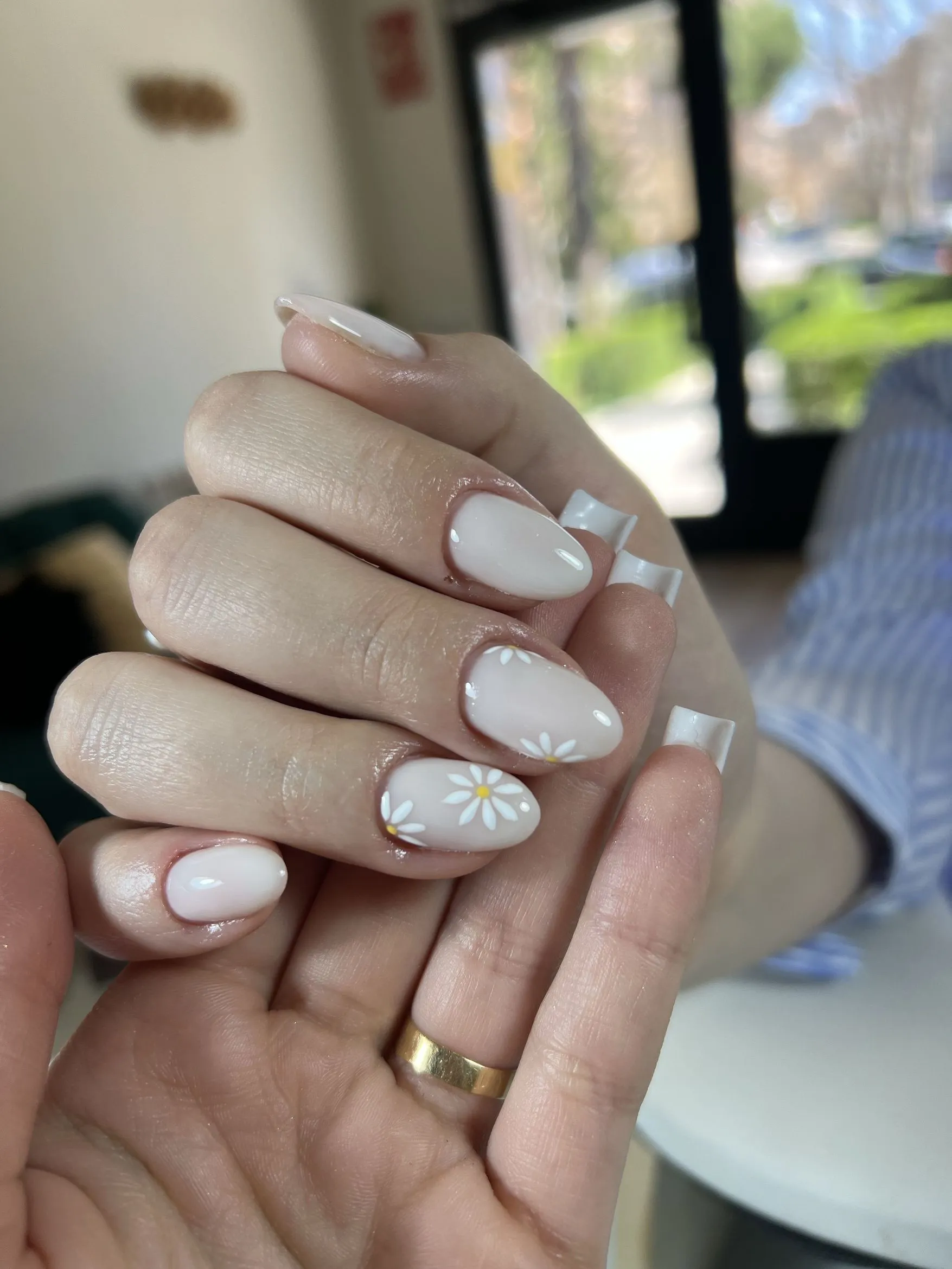 Manicura en tono nude con flores de margarita blancas
